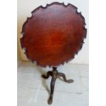 A 19th Century mahogany bird cage tilt top tripod table with a pie crust top over a carved column