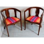 A pair of Edwardian inlaid mahogany tub chairs with decorative oval panels to back over striped