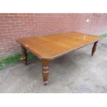 A late 19th Century golden oak extending dining table complete with two additional leaves and