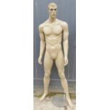 A contemporary full size male shop mannequin on a glass platform base.