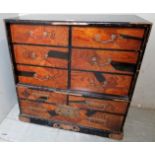 A black lacquered table top collectors cabinet with an assortment of nine marquetry inlaid drawers