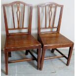 A pair of 19th Century country oak hall chairs with carved back splat's over solid seats and