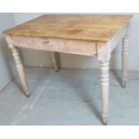 A 19th Century rustic stripped pine kitchen table with a central drawer to one side,