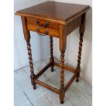 A small oak side table with two drawers over barley twist legs and lower stretchers.