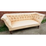 A Victorian mahogany framed three seater settee upholstered in a pale pink buttoned material