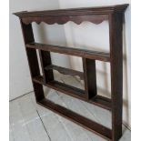 A Georgian country oak wall hanging plate rack with an assortment of open shelves.