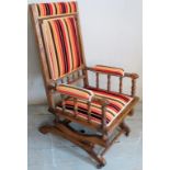 A Victorian oak framed rocking chair with bobbin turned supports over a sprung seat and finished in