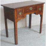 A Georgian style oak lowboy with a central drawer flanked either side by two deep drawers over a