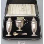 A three piece silver condiment set, comprising of salt, pepper and mustard,