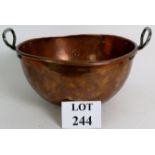 An antique heavy copper domed bowl with riveted steel handles, diameter 33cm, height 18cm.