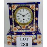 A Victorian ceramic cased mantel clock with floral and gilt decoration on a blue and white ground.