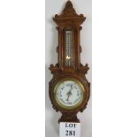 Late Victorian/Edwardian carved oak cased barometer with enamelled dial. Height is 64cm.