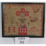 A framed antique needlework sampler depicting traditional motifs including an angel.