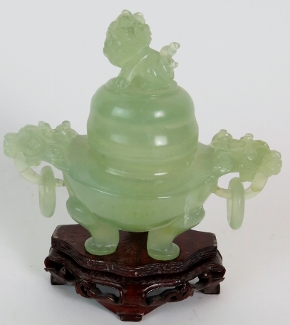 A Chinese carved jadeite dragon censer on carved wooden stand. Height: 15cm.