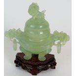A Chinese carved jadeite dragon censer on carved wooden stand. Height: 15cm.