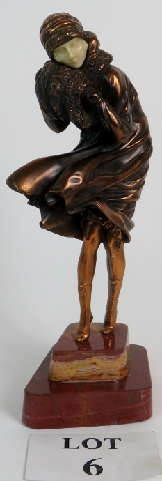 Art Deco style bronzed figure of a windswept lady in the style of Chiparus mounted on a red marble