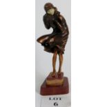 Art Deco style bronzed figure of a windswept lady in the style of Chiparus mounted on a red marble