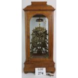 A fine ornate striking skeleton clock, in glazed oak case. Chain driven movement with bell and gone.