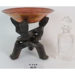 A carved African folding bowl stand with orange silvered glass bowl,