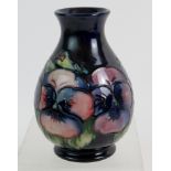 William Moorcroft bottle vase, pansy pattern on blue background, incised marks. Height is 11.5cm.