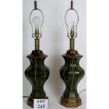 A large pair of decorative heavy brass lamp bases with green leather covering.