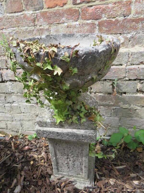 A stone garden planter urn on a small sq