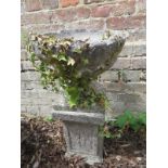 A stone garden planter urn on a small sq