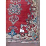 A mid 20th century Persian rug on claret