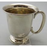 A silver christening mug with raised bas