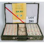 A vintage Chinese Mah Jong set in silk covered carrying case. All pieces mostly still sealed.