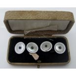 A pair of sterling silver and mother of pearl cuff links, inset with small blue cabochon stones,