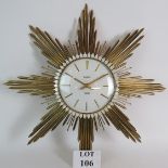 A vintage 1960's Junghans Electora sunburst wall clock with white dial and gold metal sun rays.