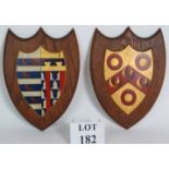 Two vintage hand painted armorial crests mounted on oak shields.