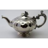 A continental silver teapot with ivory insulators on an elaborate handle and flower finial on lid,