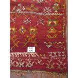 A 20's Moroccan rug, thick weave on red ground with burnt umber and white, 186cm x 138cm.