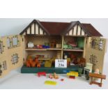 A vintage triang wooden dolls house with a full selection of dolls, furniture, rugs etc, some metal.