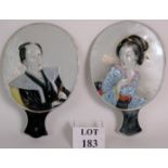 A pair of early 20th Century Japanese porcelain mirror style relief portraits of a man and a geisha.