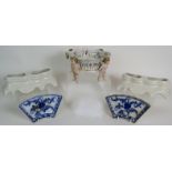 An antique German porcelain hand decorated fruit basket being supported by four Putti,