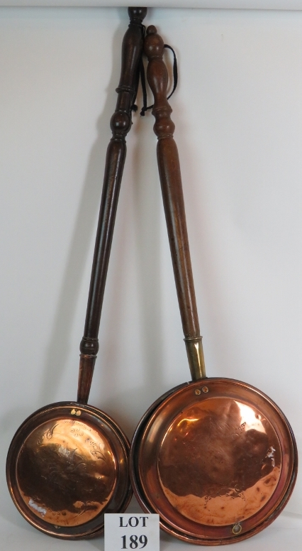 Two 19th Century heavy gauge copper bed warming pans with turned hardwood handles. Length: 108cm.
