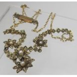 A delicate vintage style yellow metal necklace with four flower heads,