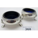 A pair of silver circular salts, with rope edge and pad feet, blue liners, Birmingham 1912,