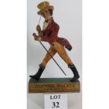 A vintage Johnnie Walker Whisky advertising figure made from composite plastic on wooden base,