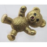 A 9ct gold Teddy bear brooch, with semi-precious blue eyes and pink nose, approx 5.4 grams.