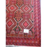 Two 20's Balouchi rugs, the first on red ground with overall geometric pattern, 210cm x 100cm.