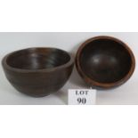 Two antique turned oak or elm dairy bowls, the larger being 29cm in diameter,