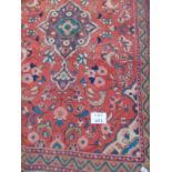 A Hamadan rug on red ground with central motif surrounded by flowers.