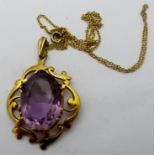 A large oval cut amethyst pendant, set in a 9ct gold mount of scrolls and open work design,