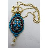 An elaborate and fine quality oval yellow metal pendant with turquoise, rubies, diamonds and pearls,