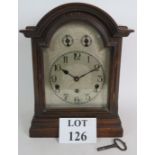 An antique oak cased striking mantel clock with Westminster chimes, manufactured by Kienzle.