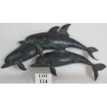 A contemporary heavy cast bronze wall sculpture of three leaping dolphins,